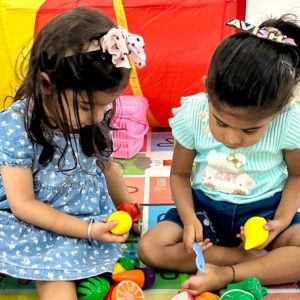 teacher-preschool-students-playing-with-balls-sitt-min